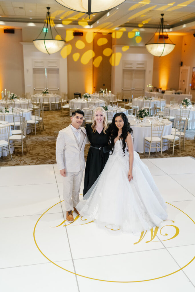Wedding planner with a newlywed couple at a wedding reception.